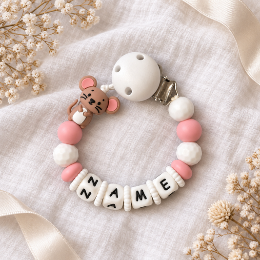 Personalisierte Schnullerkette mit Maus in Rosa und Weiß auf weißem Musselin